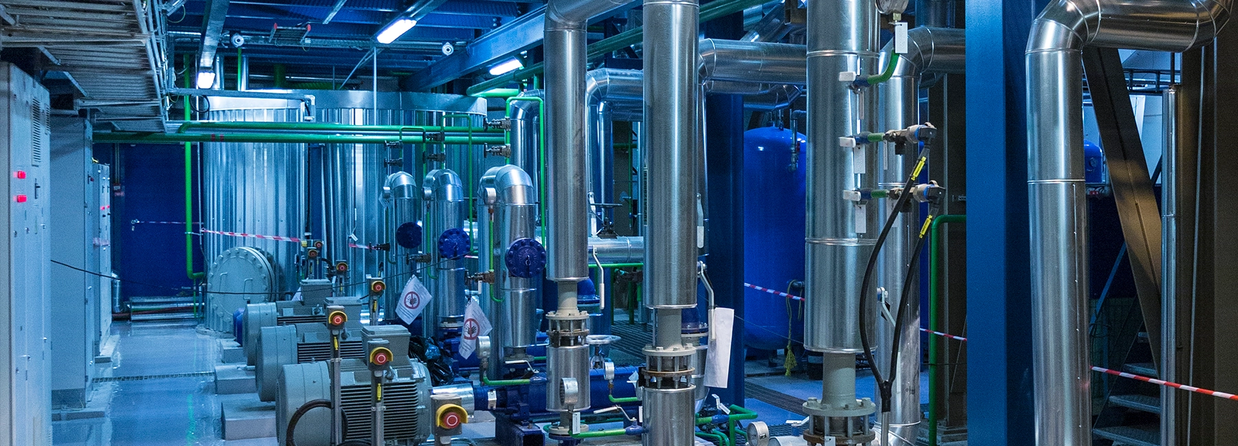 Industrial power systems setup featuring large metal pipes, valves, and motors in a clean, well-lit facility.